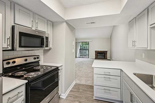 A kitchen with a black stove top oven and white cabinets.