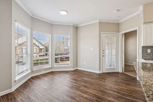 A room with wooden floors and a large window.