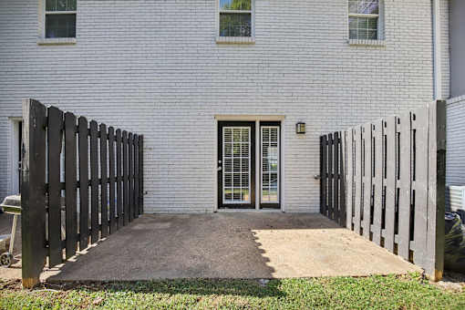A white house with a black fence and a glass door.