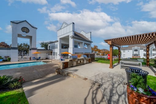 a patio with a pool and a building with a clock on the side