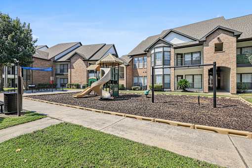 A playground area in front of a row of houses.