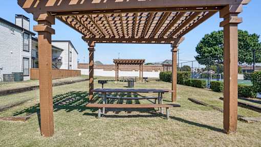Wooden pergola with a bench underneath it at Keller Oaks, Carrollton, TX 75006