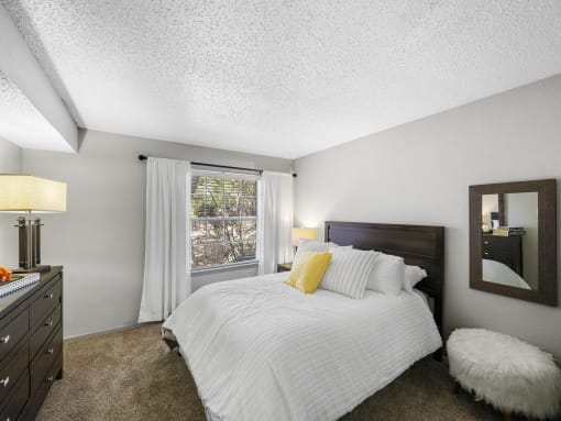 a bedroom with a bed and a dresser with a mirror