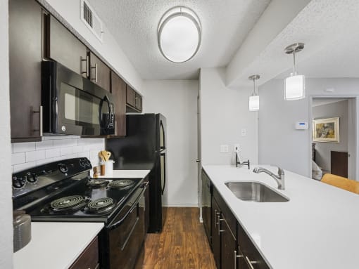 a kitchen with white countertops and black appliances