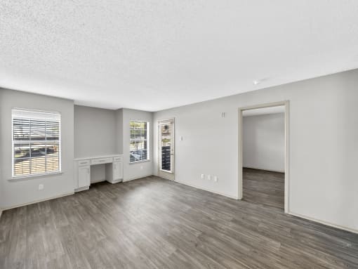 an empty living room with hardwood flooring