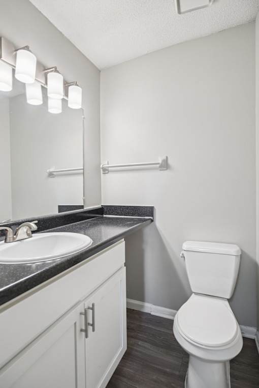 A white toilet sits in a bathroom next to a sink.