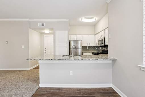 A kitchen with a white countertop and a sink.