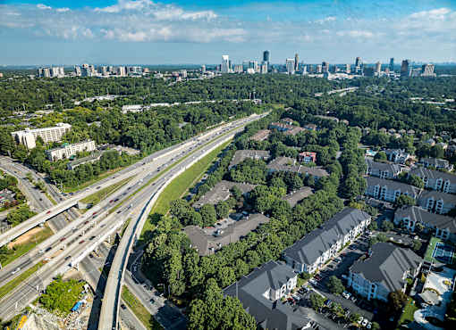 A highway interchange with a city skyline in the distance.