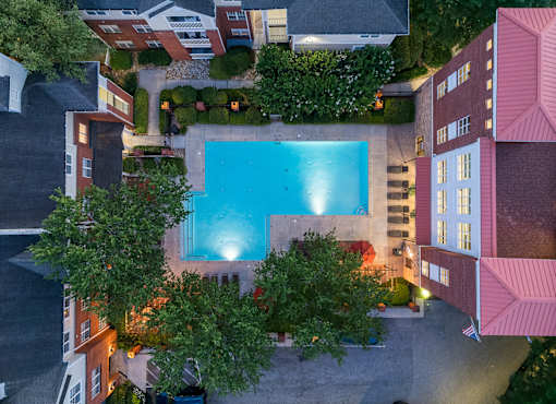 A swimming pool surrounded by buildings and trees.