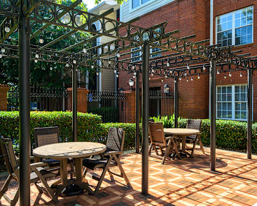 A patio with a table and chairs under a pergola.