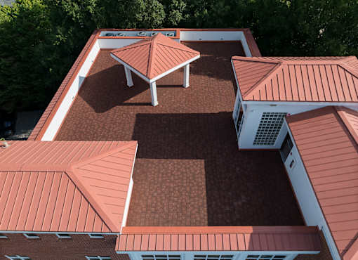 A building with red roofs and a white section on the side.
