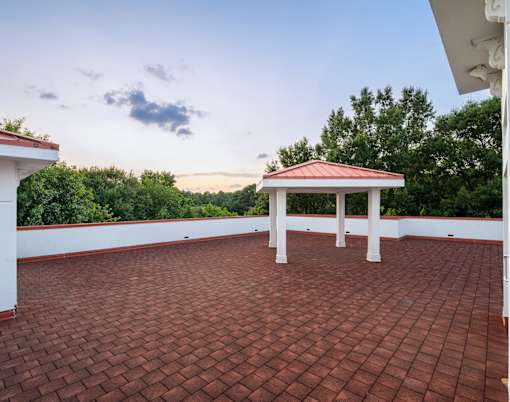 A gazebo sits on a red brick patio.