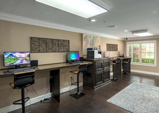 A room with a desk, computer, and chair.