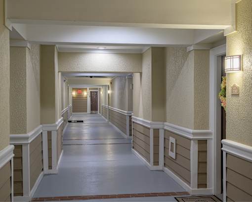 A long hallway with a red carpet and white walls.