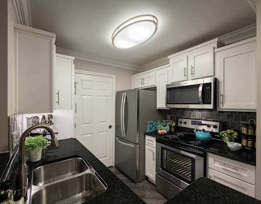 A modern kitchen with a stainless steel refrigerator, oven, and microwave.