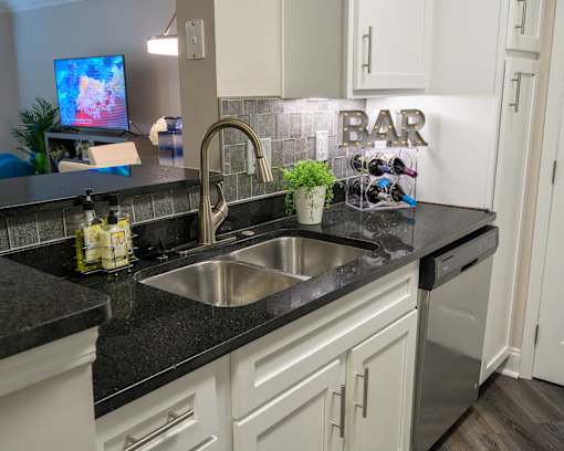 A kitchen with a sink and a sign that says "BAR".