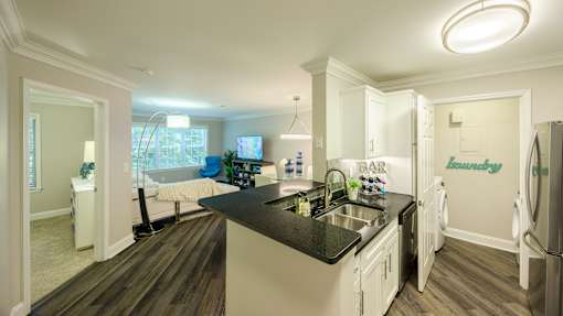 A kitchen with a black counter top and white cabinets.