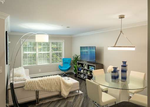 A modern living room with a glass table and a blue chair.