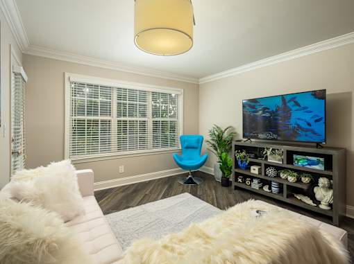 A living room with a blue chair and a television.