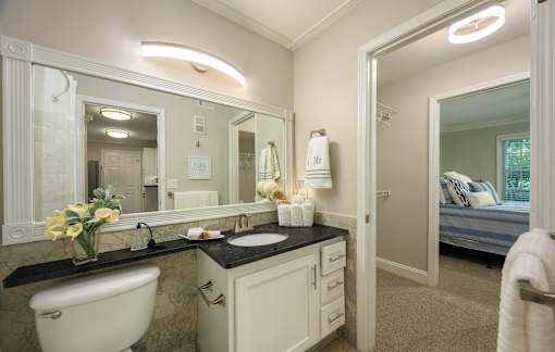 A bathroom with a white tub, sink, and mirror.