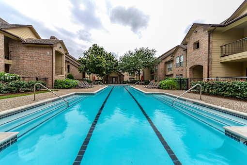 A swimming pool in front of apartment buildings.
