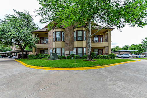 A large apartment complex with a parking lot in front.