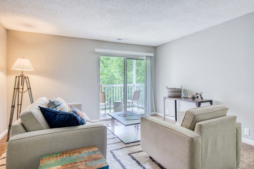 a living room with a couch and a chair and a sliding glass door aat The Grove Brentwood, Nashville Tennessee?