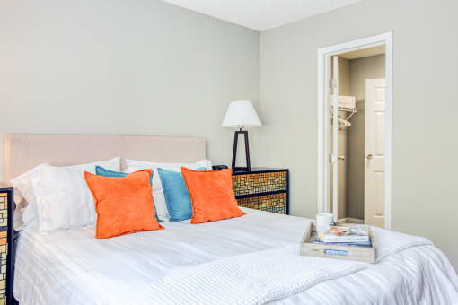 a bedroom with a bed with blue and orange pillows at The Grove Brentwood, Nashville Tennessee?