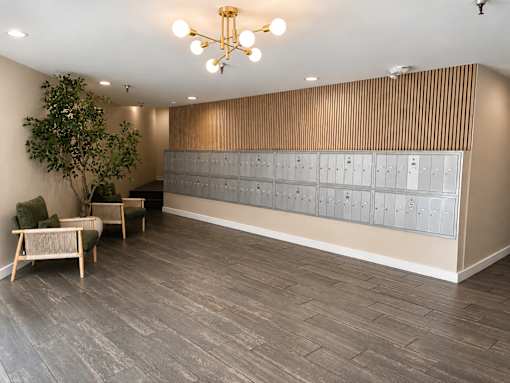 A room with a wooden floor and a wall with a row of lockers.