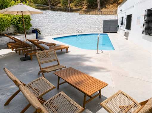 A pool with a table and chairs around it.