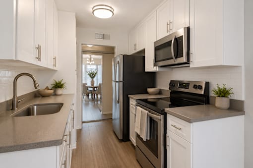 A kitchen with black appliances and white cabinets.
