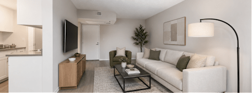 A modern living room with a white couch, a black coffee table, and a flat-screen TV.