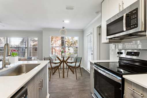 A kitchen with a table and chairs in the middle.