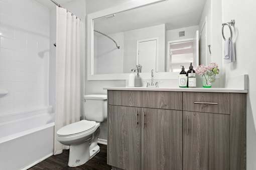 A white toilet sits in a bathroom next to a wooden cabinet.