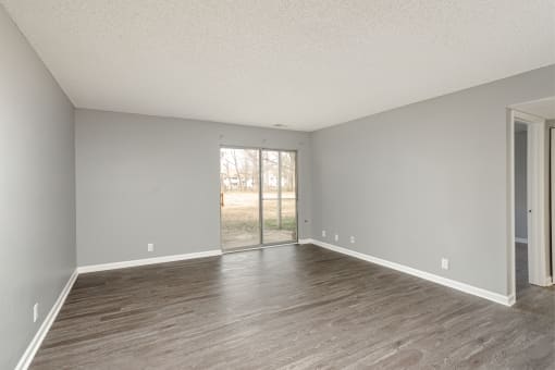 an empty living room with wood floors and a sliding glass door at The Grove Brentwood, Tennessee ?