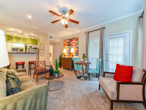 A living room with a ceiling fan and a couch.