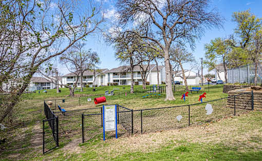 A sign in a fenced area with a red mailbox and a blue signboard.