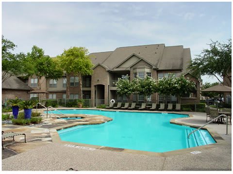 A large house with a pool in front.