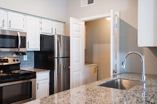 A kitchen with granite countertops and white cabinets.