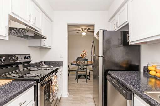 A kitchen with black appliances and white cabinets.