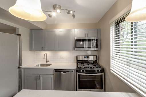 A modern kitchen with stainless steel appliances and a white countertop.