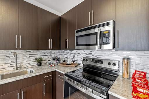 A modern kitchen with a stainless steel oven and microwave.