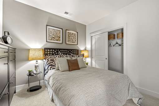 A bedroom with a large bed and a nightstand with a lamp.