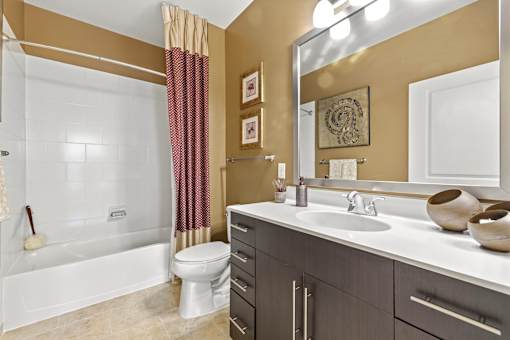 A bathroom with a white tub, toilet, and sink.