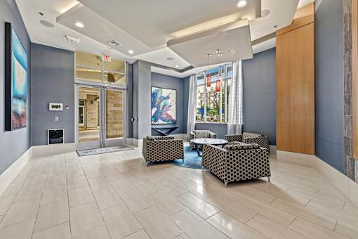 A spacious lobby with a fireplace and a large painting on the wall.