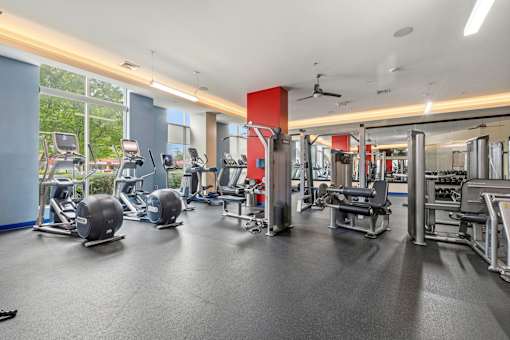 A gym with a variety of equipment including weights and cardio machines.