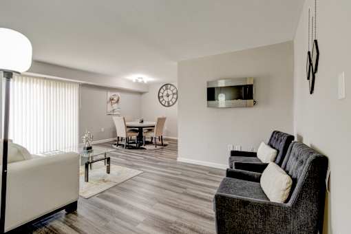 A living room with a grey couch and a white sofa.