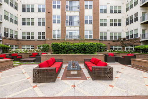 A courtyard with red couches and a fountain in the middle.