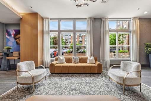 A living room with a sofa, two chairs and a rug.