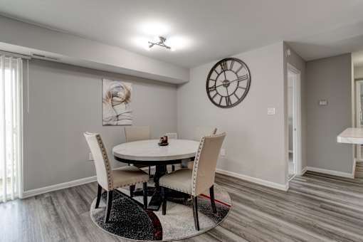 A dining room with a round table and chairs.